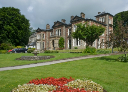 An elegant care home, featuring a spacious mansion and a charming flower garden