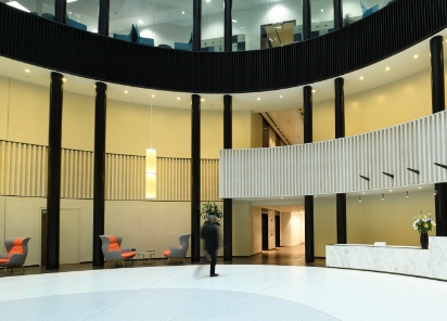 Circular lobby of a building, featuring modern architecture and an individual walking through the middle