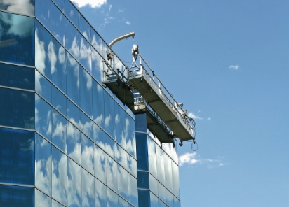 Cradle suspended on the side of a high-rise glass building